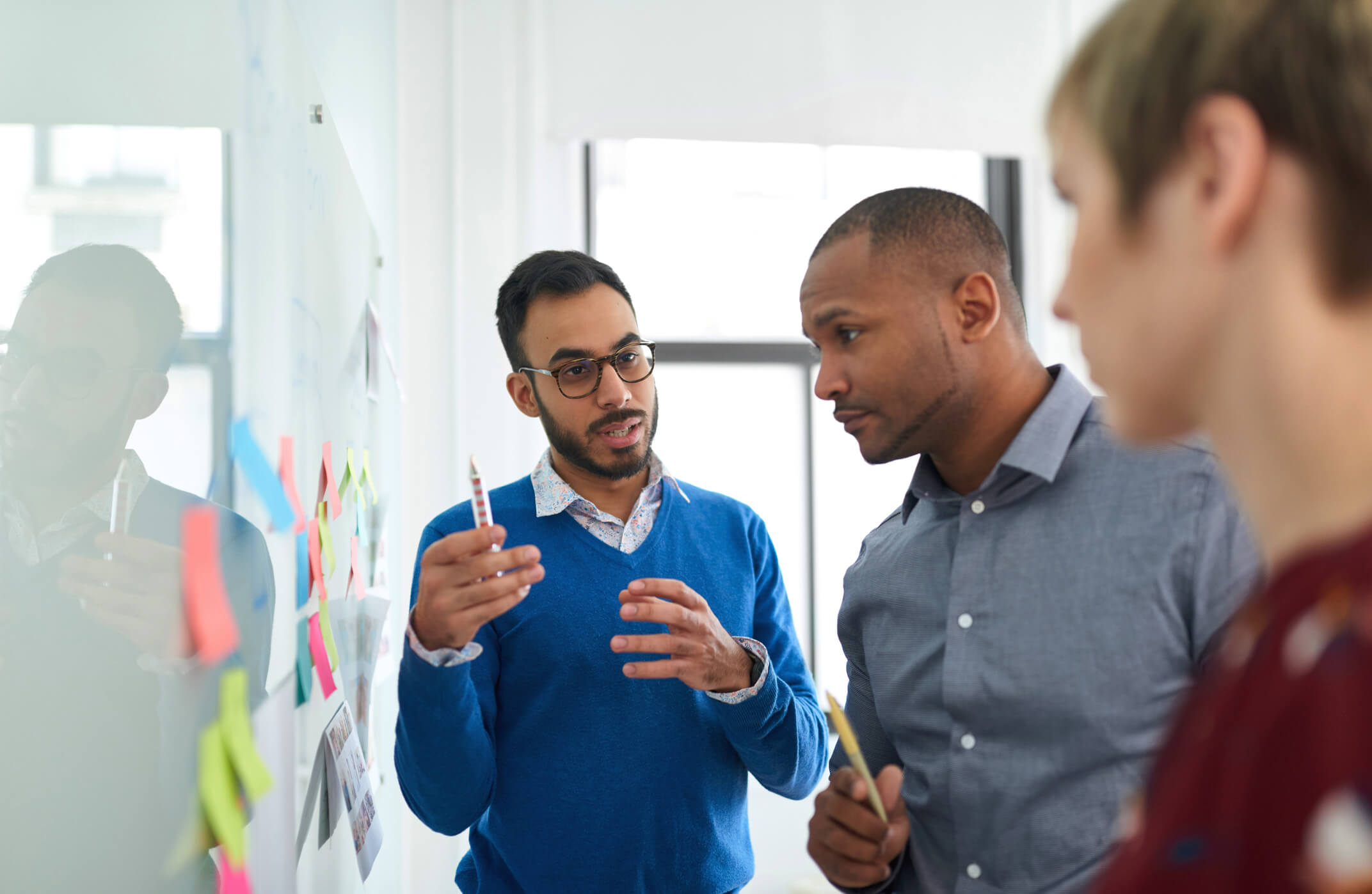 Image of a team studying a note-covered whiteboard